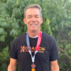 man smiling at camera with fitness medal around neck