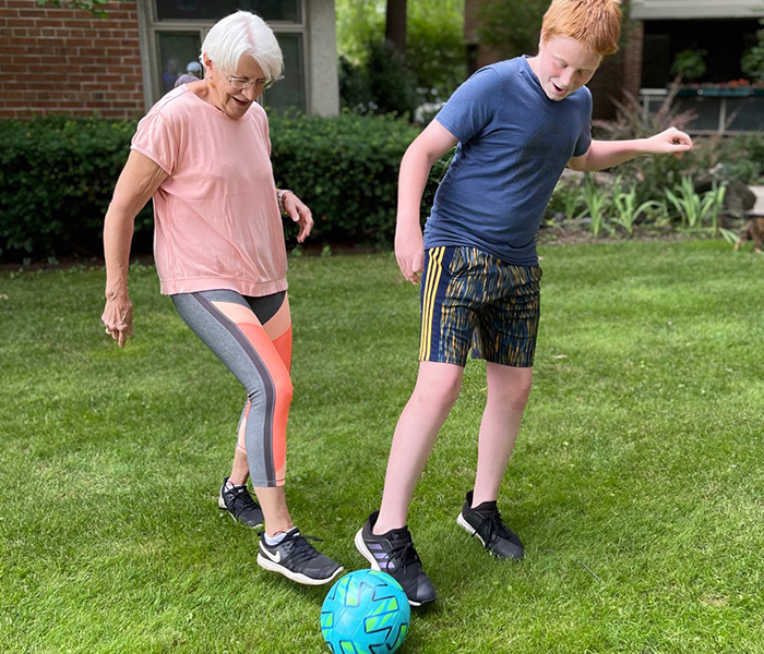 grandmother and grandson playing soccer